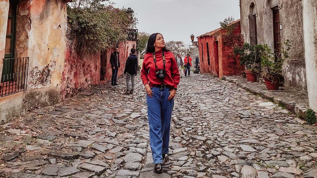 A woman exploring Calle de los Suspiros, a must-visit attraction during the day trip to Colonia del Sacramento.